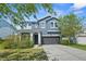 Charming two-story home with a well-maintained lawn, flowering bushes, and a gray two car garage at 11503 Quiet Forest Dr, Tampa, FL 33635