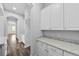 Charming hallway featuring white cabinets, granite countertops, and hardwood flooring at 11503 Quiet Forest Dr, Tampa, FL 33635