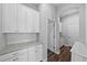 Charming hallway featuring white cabinets, granite countertops, and hardwood flooring at 11503 Quiet Forest Dr, Tampa, FL 33635