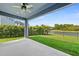 Covered patio with ceiling fan overlooking manicured lawn and waterfront at 11503 Quiet Forest Dr, Tampa, FL 33635