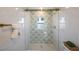 Shower with decorative green leaf pattern tile, glass door, with gold hardware at 1160 36Th N Ave, St Petersburg, FL 33704