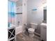 Bathroom featuring a tub with shower, tile details, beach themed shower curtain, and decorative wall art at 1226 S Missouri Ave # 1013, Clearwater, FL 33756