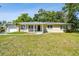 Inviting one-story home boasts a covered front porch and lush green lawn in a desirable neighborhood at 1231 27Th S Ave, St Petersburg, FL 33705