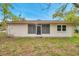 Rear view of the home featuring a screened-in lanai and a private backyard, perfect for relaxing or entertaining at 13102 Wagner Dr, Hudson, FL 34667