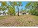A spacious backyard featuring mature trees, a well-maintained lawn, and a charming single-Gathering home at 13102 Wagner Dr, Hudson, FL 34667