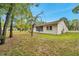 Exterior shot of home displaying a screened in patio, updated windows and mature trees in backyard at 13102 Wagner Dr, Hudson, FL 34667