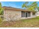 Exterior image of home displaying screened in porch and blossoming bush at 13102 Wagner Dr, Hudson, FL 34667