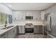 This modern kitchen features stainless steel appliances, grey cabinets, and sleek countertops at 13102 Wagner Dr, Hudson, FL 34667