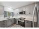 Updated kitchen with stainless steel appliances, white cabinets, and granite countertops at 13102 Wagner Dr, Hudson, FL 34667