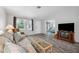 Cozy living room with wood-look flooring and view into the bedroom at 13102 Wagner Dr, Hudson, FL 34667