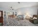 Inviting living room featuring a vaulted ceiling, ceiling fan, gray flooring, dining table and comfortable seating at 13102 Wagner Dr, Hudson, FL 34667