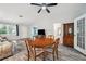 Living room with ceiling fan, dining table and chairs, gray wood-look flooring, and plenty of natural light at 13102 Wagner Dr, Hudson, FL 34667