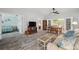 Spacious living room with a ceiling fan, wood-look floors, and views to the backyard at 13102 Wagner Dr, Hudson, FL 34667