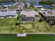 Aerial view showcases a waterfront home with screened pool and lush landscaping in a neighborhood at 1804 Bunker Hill Dr, Sun City Center, FL 33573