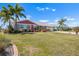 Beautiful home features mature palm trees, green lawn, and colorful landscaping at 1804 Bunker Hill Dr, Sun City Center, FL 33573