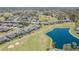 Aerial view showcasing homes near a golf course with a pond, sand traps, and green fairways at 18836 Summersong Dr, Hudson, FL 34667