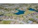 Aerial view of homes nestled around a scenic lake and golf course in a vibrant community at 18836 Summersong Dr, Hudson, FL 34667