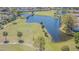 Aerial view of homes surrounding a lake and golf course, connected by a scenic wooden bridge at 18836 Summersong Dr, Hudson, FL 34667