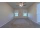 Bright and airy bedroom with neutral carpet, a ceiling fan, and two large windows that offer great natural light at 18836 Summersong Dr, Hudson, FL 34667