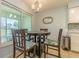 Cozy dining area with a charming chandelier, a decorative mirror, and a large window overlooking the backyard at 18836 Summersong Dr, Hudson, FL 34667