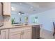 Stylish kitchen with a stainless steel dishwasher and a large center island featuring a stone countertop at 18836 Summersong Dr, Hudson, FL 34667