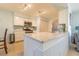 Well-lit kitchen featuring white cabinetry, stainless steel appliances, and a large island with a stone countertop at 18836 Summersong Dr, Hudson, FL 34667
