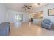 Bright living room features tile flooring, a ceiling fan, and a sliding glass door to the outside at 18836 Summersong Dr, Hudson, FL 34667
