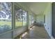 Screened patio with wood floors, offering a serene view of the landscaped yard, ideal for outdoor seating at 18836 Summersong Dr, Hudson, FL 34667