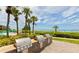 Community grilling area with palm trees and a beautiful beach view at 2055 Gulf Of Mexico Dr # G2-213, Longboat Key, FL 34228