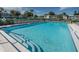 Community pool with rows of lounge chairs and a view of the condo buildings on a sunny day at 232 Nina Way # 232, Oldsmar, FL 34677