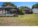 Backyard with a screened-in pool area, green grass, and trees at 2412 Arborwood Dr, Valrico, FL 33596