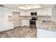 A modern kitchen featuring white cabinets, stainless steel appliances, and granite countertops at 2412 Arborwood Dr, Valrico, FL 33596