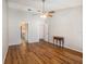 Open living room with wood floors, a ceiling fan, and a hallway leading to the bathroom and bedrooms at 2412 Arborwood Dr, Valrico, FL 33596