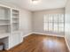 The office space showcases wood floors, a built-in desk with shelving, and a large window at 2412 Arborwood Dr, Valrico, FL 33596