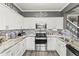 Bright kitchen with stainless steel appliances, granite countertops, and elegant white cabinets at 2759 Conch Hollow Dr, Brandon, FL 33511