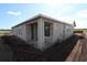 New construction exterior featuring block walls, modern windows, and a covered entry, ready for finishing touches at 2801 Marrakesh Ln, Sarasota, FL 34234