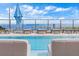 Ocean view from the rooftop pool with blue umbrellas, lounge chairs and boat masts on the horizon at 301 1St S St # 3207, St Petersburg, FL 33701