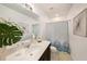 Bright bathroom showcasing a modern vanity with quartz countertop and decorative shower curtain at 30364 Marquette Ave, Wesley Chapel, FL 33545
