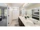 Bathroom featuring a double sink vanity, white tiled floors, and bright natural lighting at 30364 Marquette Ave, Wesley Chapel, FL 33545