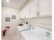 Clean laundry room with white cabinets, modern washer and dryer, and stainless steel sink at 30364 Marquette Ave, Wesley Chapel, FL 33545