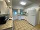 Bright kitchen with white cabinetry, granite counters, and access to backyard views from the window at 3204 W Clinton St, Tampa, FL 33614