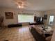 Bright living room featuring a glass block window, tile flooring, and comfortable seating arrangement at 3204 W Clinton St, Tampa, FL 33614