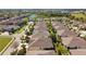 A panoramic aerial view captures a residential neighborhood with well-maintained homes and green spaces, including a pond at 32853 Woodthrush Way, Wesley Chapel, FL 33545