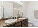 This bathroom features double sinks with granite counters and tiled floors at 32853 Woodthrush Way, Wesley Chapel, FL 33545