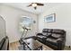 Bright bedroom featuring a comfortable couch, wood-look floors, and a ceiling fan for added comfort at 32853 Woodthrush Way, Wesley Chapel, FL 33545
