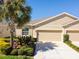 Charming single-story home with a well-manicured lawn, lush landscaping, and a two-car garage, exuding curb appeal at 32853 Woodthrush Way, Wesley Chapel, FL 33545