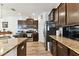 Well-equipped kitchen featuring dark wood cabinets, stainless steel appliances, and granite countertops at 32853 Woodthrush Way, Wesley Chapel, FL 33545