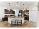Well-lit kitchen with dark cabinets, granite countertops, stainless steel appliances, and a center island with barstool seating at 32853 Woodthrush Way, Wesley Chapel, FL 33545