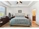 Serene main bedroom with a tray ceiling, a comfortable bed, and an ensuite bathroom, creating a private retreat at 32853 Woodthrush Way, Wesley Chapel, FL 33545
