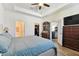 Comfortable main bedroom with ample closet space, a tray ceiling, and easy access to the ensuite bathroom and other rooms at 32853 Woodthrush Way, Wesley Chapel, FL 33545